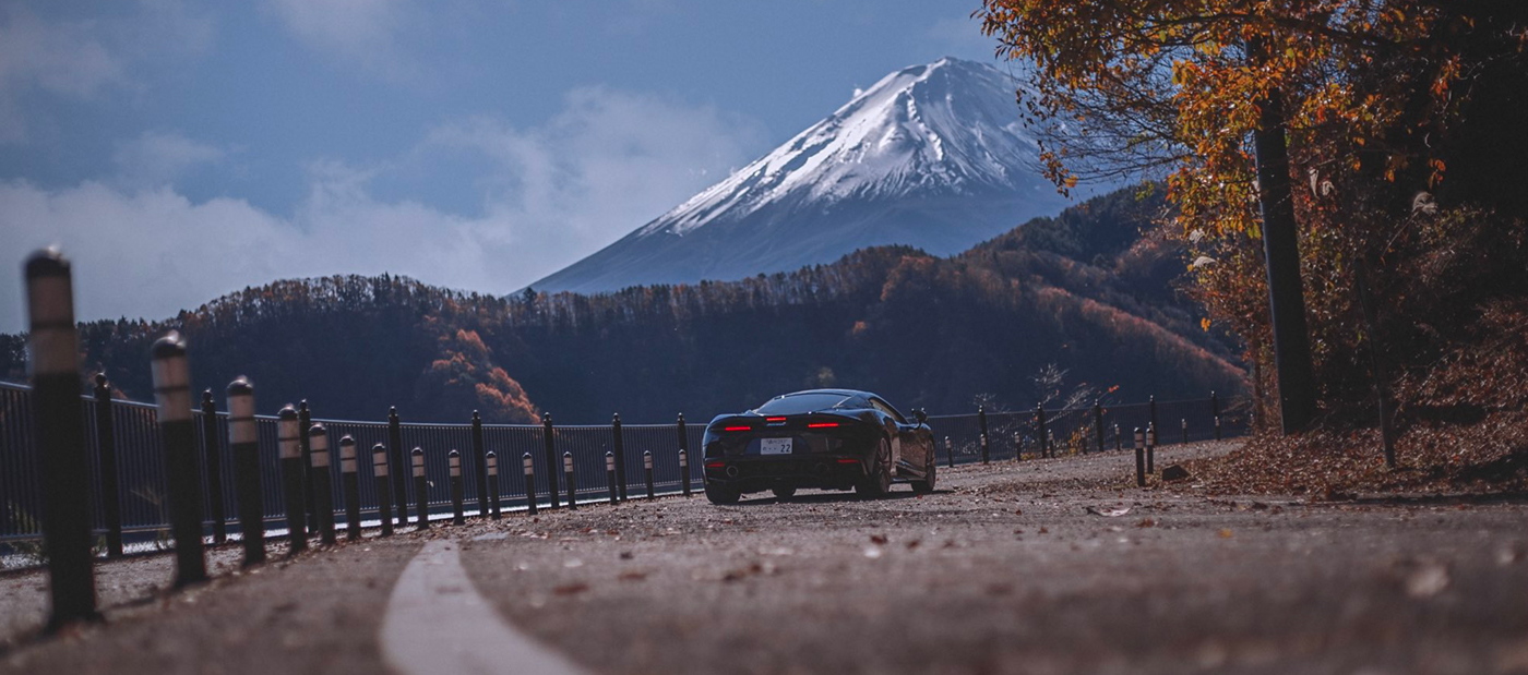 The McLaren GT on a curve in the road with Mt Fuji in the background